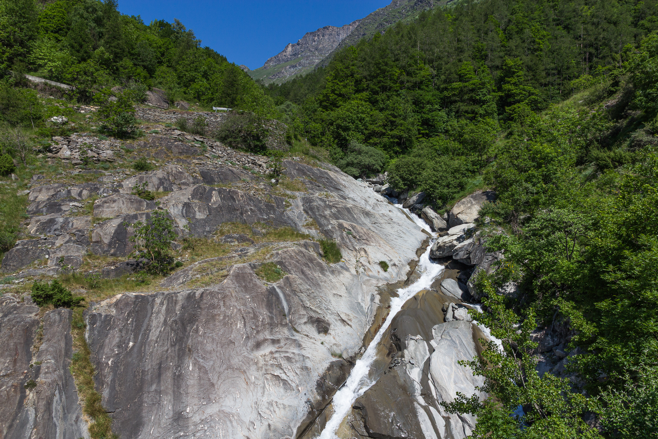 Wasserfall über glatt geschliffene Felsplatten im Aufstieg